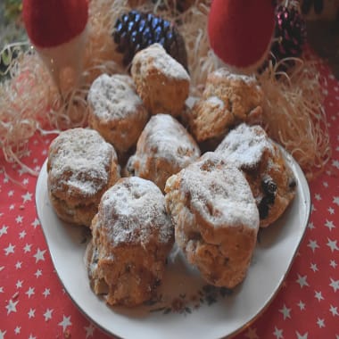 Christmas Stollen Scones on a white plate on a red patterned Christmas themed background.